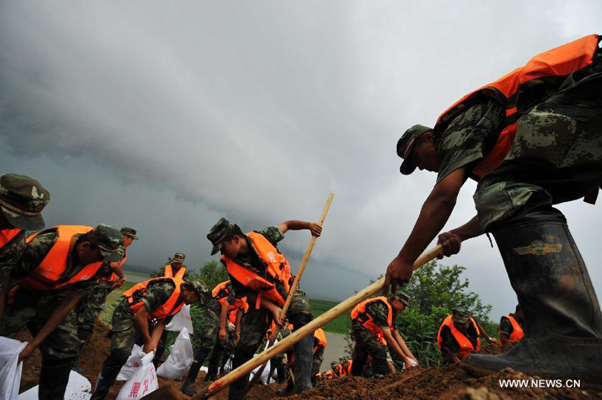 A contingent of local armed police forest corps consolidate the bank of the Heilongjiang River in Sunwu County of Heihe City, northeast China&apos;s Heilongjiang Province, Aug. 8, 2013. Continuous downpours since July left floodwater from tributaries to flow into the Heilongjiang River, putting much pressure on flood control in the lower reaches. As of Tuesday, the water level of the Heilongjiang River in Heihe reached 96.66 meters, surpassing the record level recorded in 1998 by 0.6 meters. 