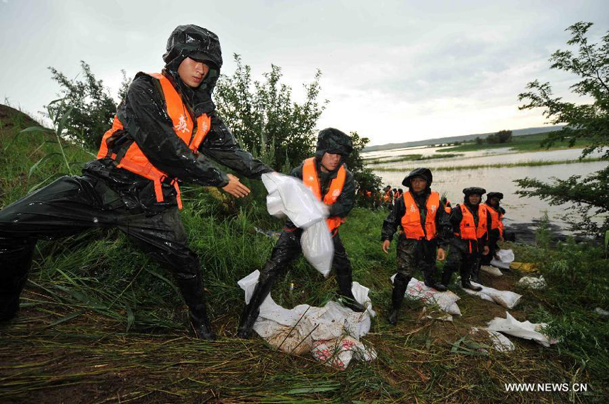 A contingent of local armed police forest corps consolidate the bank of the Heilongjiang River in Sunwu County of Heihe City, northeast China&apos;s Heilongjiang Province, Aug. 8, 2013. Continuous downpours since July left floodwater from tributaries to flow into the Heilongjiang River, putting much pressure on flood control in the lower reaches. As of Tuesday, the water level of the Heilongjiang River in Heihe reached 96.66 meters, surpassing the record level recorded in 1998 by 0.6 meters.