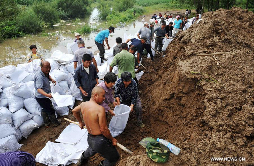 Locals consolidate a river bank in the Aihui District of Heihe City, northeast China&apos;s Heilongjiang Province, Aug. 8, 2013. Continuous downpours since July left floodwater from tributaries to flow into the Heilongjiang River, putting much pressure on flood control in the lower reaches. As of Tuesday, the water level of the Heilongjiang River in Heihe reached 96.66 meters, surpassing the record level recorded in 1998 by 0.6 meters.