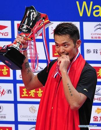 Lin Dan of China reacts during the medal presenting ceremony after men's single final match against Lee Chong Wei of Malaysia at the 2013 BWF World Championships in Guangzhou, capital of south China's Guangdong Province, Aug. 11, 2013. Lin Dan claimed the title as Lee Chong Wei retired in the match.