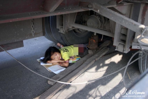 A girl is seen trapped under the wheels of a trailer on August 9, 2013 in Anyang of central China's Henan province.