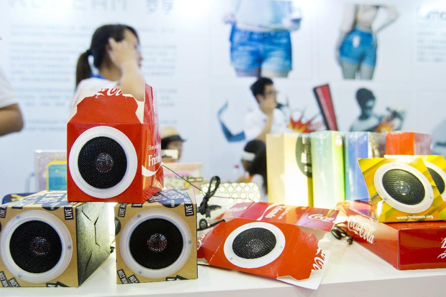 Visitors watch the displayed golden products during the 28th China Beijing International Gifts, Premium and Houseware Exhibition in Beijing, capital of China, Aug 14, 2013. The four-day exhibition, with the participation of 1,500 exhibitors from both home and abroad, opened on Wednesday. [Photo/Xinhua]