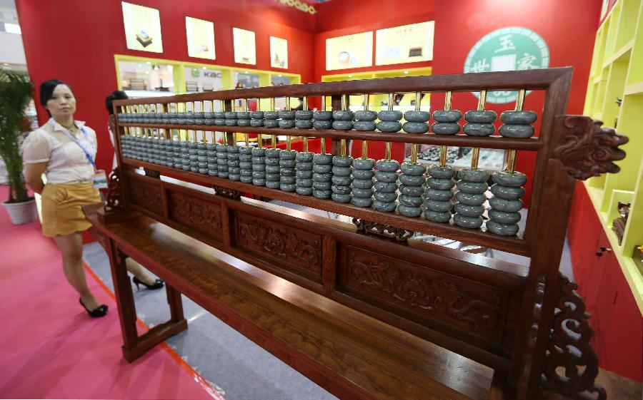 A visitor watches a large-scale abacus during the 28th China Beijing International Gifts, Premium and Houseware Exhibition in Beijing, capital of China, Aug 14, 2013. The four-day exhibition, with the participation of 1,500 exhibitors from both home and abroad, opened on Wednesday. [Photo/Xinhua]