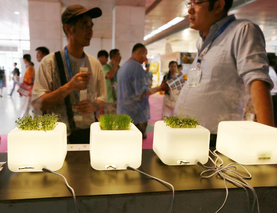 Visitors watch the displayed air moisteners during the 28th China Beijing International Gifts, Premium and Houseware Exhibition in Beijing, capital of China, Aug 14, 2013. The four-day exhibition, with the participation of 1,500 exhibitors from both home and abroad, opened on Wednesday. [Photo/Xinhua]