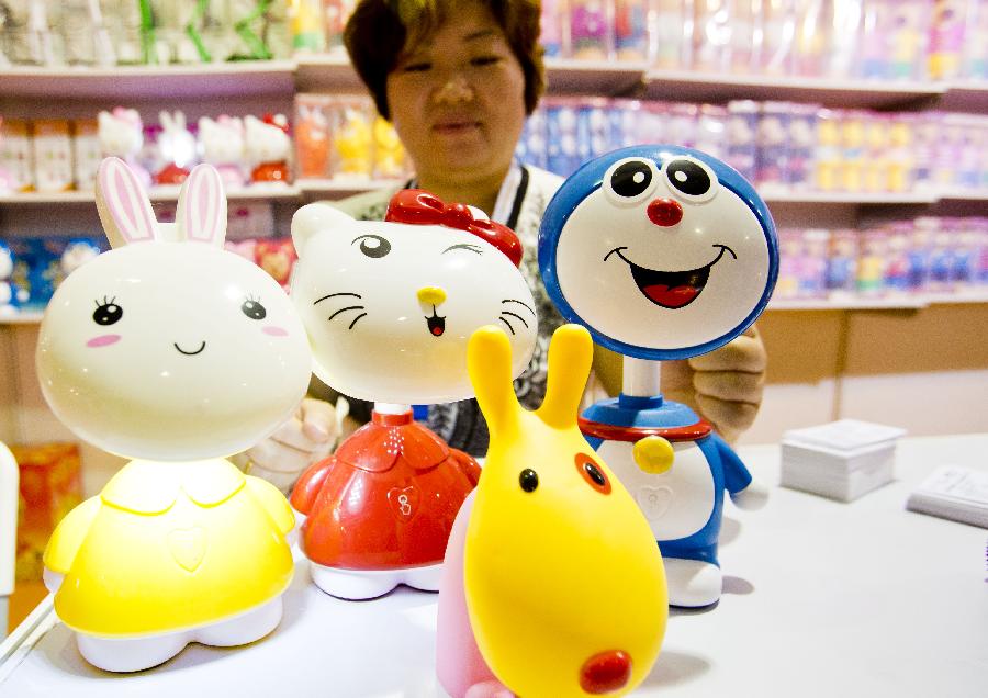 An exhibitor shows a type of reading lamp during the 28th China Beijing International Gifts, Premium and Houseware Exhibition in Beijing, capital of China, Aug. 14, 2013. The four-day exhibition, with the participation of 1,500 exhibitors from both home and abroad, opened on Wednesday. [Photo / Xinhua] 