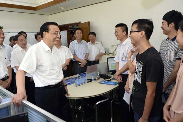 Premier Li Keqiang shares a light moment with students during his visit to Lanzhou University, Gansu province, on Sunday. The premier urges students to remain confident of the job market. [Tang Mingming / For China Daily]