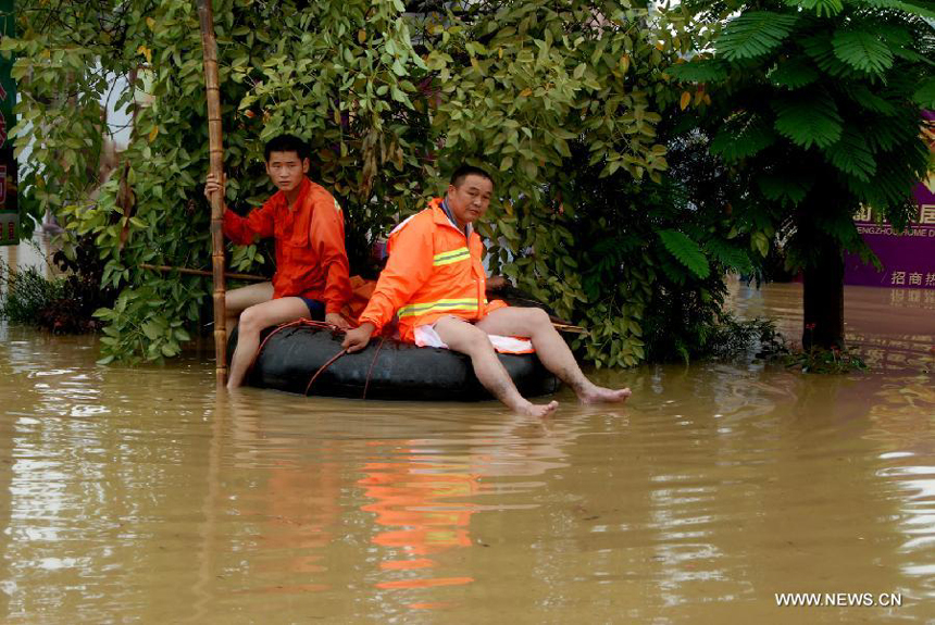 Two men wait to be rescued in Hanguang Town of Yingde City, south China&apos;s Guangdong Province, Aug. 18, 2013. 