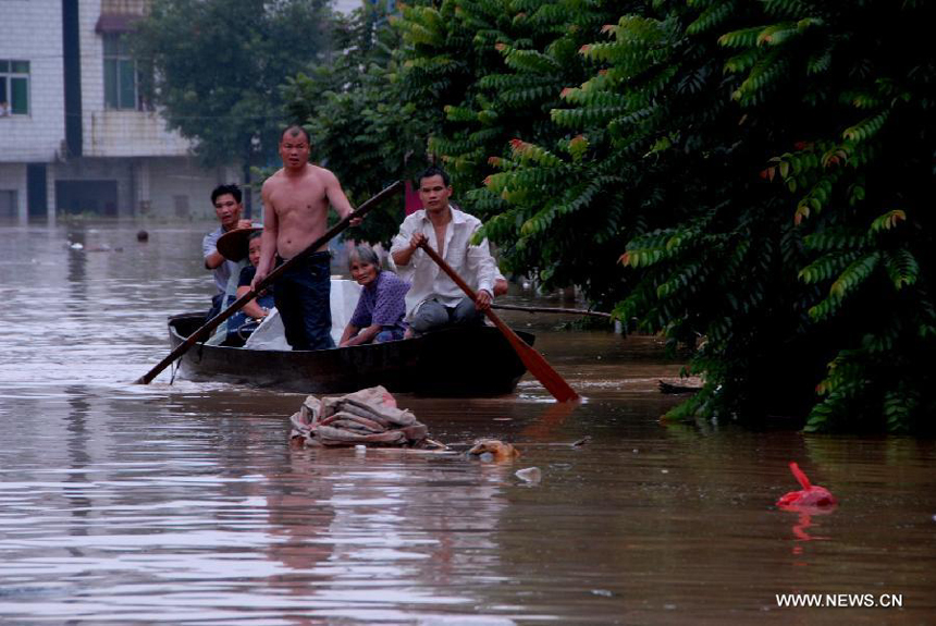 Local residents row a boat to rescue people trapped by flood in Hanguang Town of Yingde City, south China&apos;s Guangdong Province, Aug. 18, 2013. 