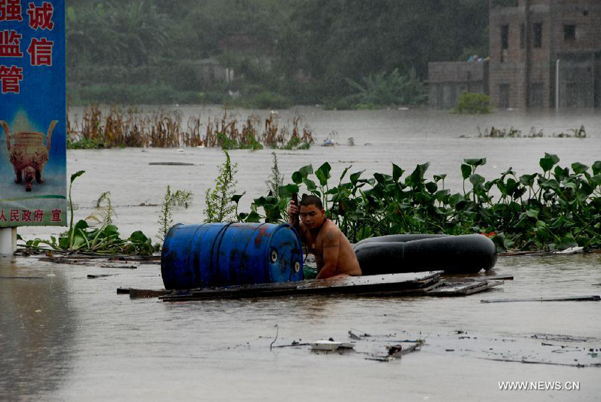 A man waits to be rescued in Hanguang Town of Yingde City, south China&apos;s Guangdong Province, Aug. 18, 2013. 