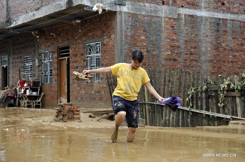 A woman walks in silt in Yangtou Village of Zijin County in Heyuan City, south China&apos;s Guangdong Province, Aug. 18, 2013. 