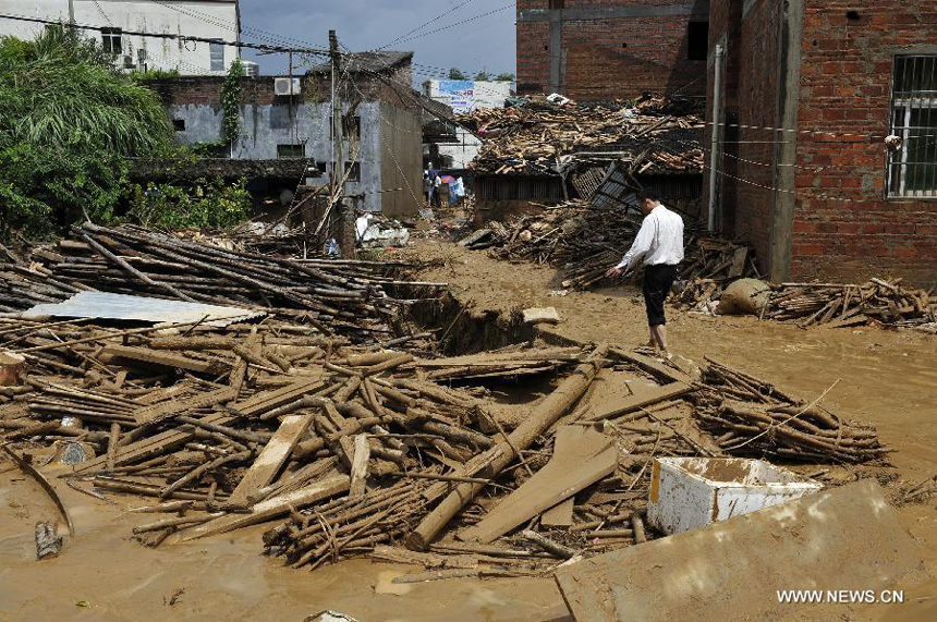 A man walks past a shattered house in Yangtou Village of Zijin County in Heyuan City, south China&apos;s Guangdong Province, Aug. 18, 2013. 