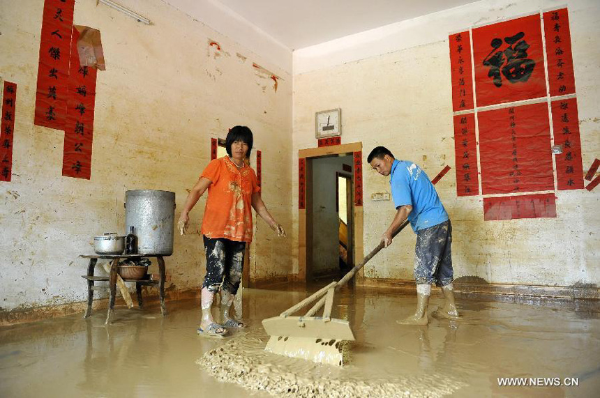 Villagers clean silt in their house in Yangtou Village of Zijin County in Heyuan City, south China&apos;s Guangdong Province, Aug. 18, 2013. 