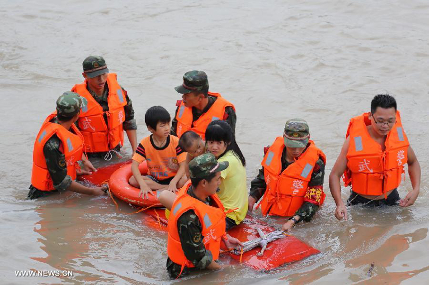 Flood-affected residents are displaced in Puning, south China&apos;s Guangdong Province, Aug. 18, 2013. Floods triggered by continuous downpours since Aug. 16 have left eight people dead in Puning. More than 100,000 people stranded by floods were evacuated to safe place. 