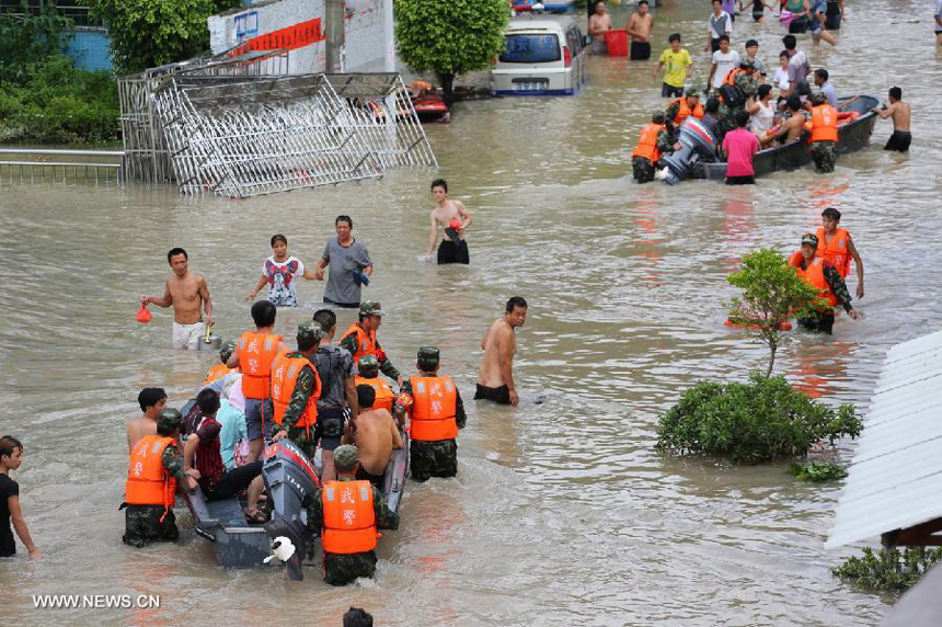 Flood-affected residents are displaced in Puning, south China&apos;s Guangdong Province, Aug. 18, 2013. Floods triggered by continuous downpours since Aug. 16 have left eight people dead in Puning. More than 100,000 people stranded by floods were evacuated to safe place.