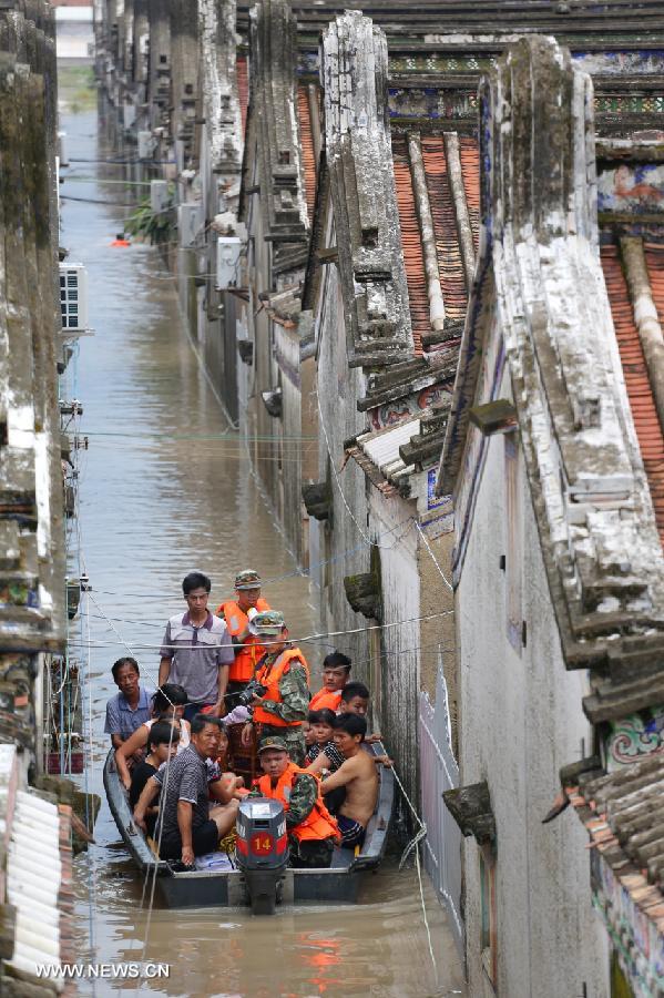 Flood-affected residents are displaced in Puning, south China&apos;s Guangdong Province, Aug. 18, 2013. Floods triggered by continuous downpours since Aug. 16 have left eight people dead in Puning. More than 100,000 people stranded by floods were evacuated to safe place. 