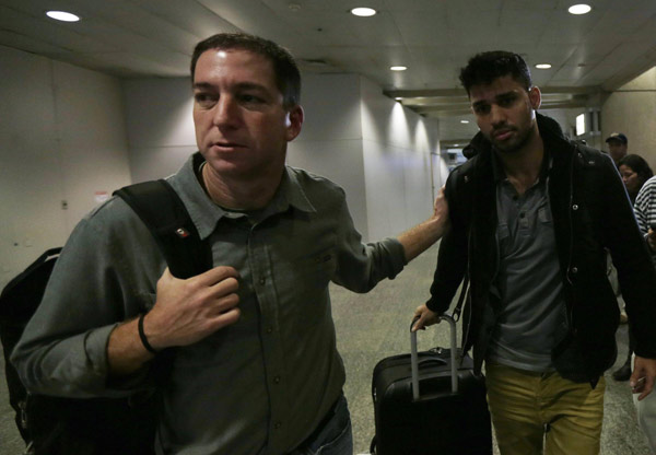 US journalist Glenn Greenwald (L) walks with his partner David Miranda in Rio de Janeiro's International Airport August 19, 2013. British authorities used anti-terrorism powers on Sunday to detain Miranda, the partner of Greenwald, who has close links to Edward Snowden, the former US spy agency contractor who has been granted asylum by Russia, as he passed through London's Heathrow airport. [Agencies via China Daily]