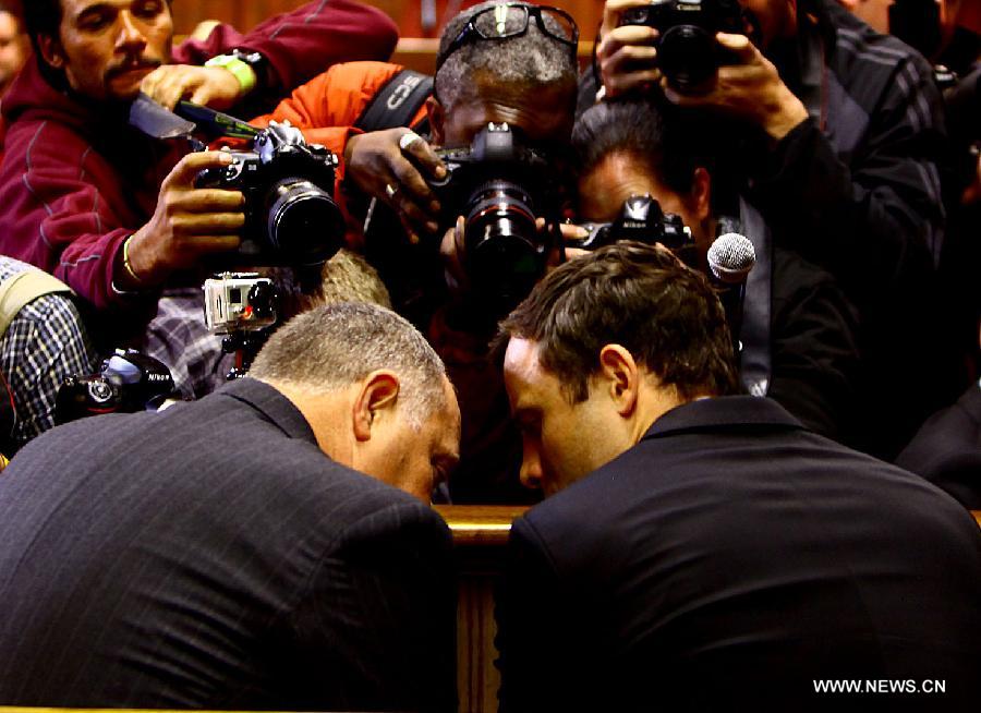 Paralympic running star Oscar Pistorius (R) reacts inside the magistrates court in Pretoria, South Africa, on Aug.19, 2013. Pistorius was back in court Monday morning to hear murder charges against him.