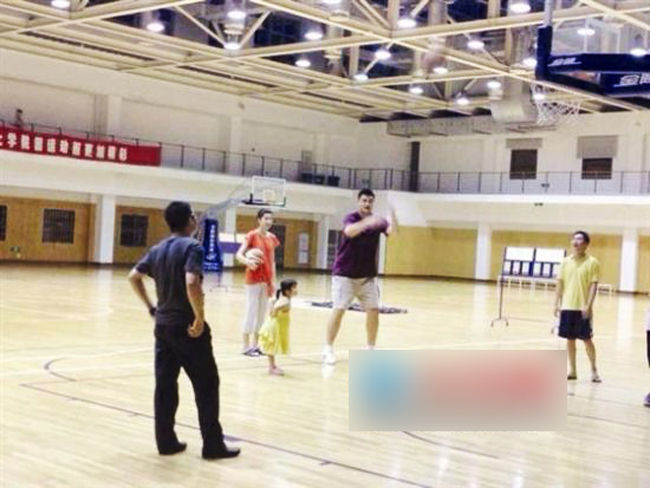 A photo taken on August 19, 2013 shows Yao Ming is teaching his taughter to play basketball.