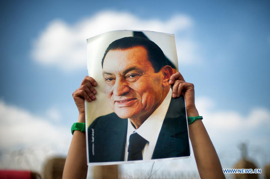 Photo taken on April. 13, 2013 shows a supporter holds a poster of Egyptian former President Hosni Mubarak during a demonstration in Cairo, Egypt. An Egypt court ordered to release former President Hosni Mubarak in his last corruption case, independent Hayat channel reported on Wednesday. 