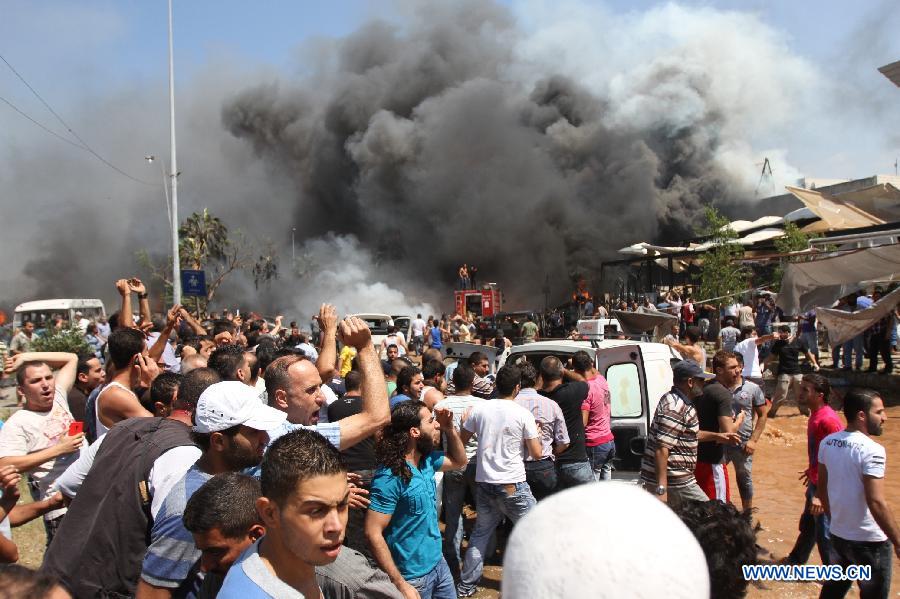 People react as smoke rises from the blast site in Tripoli, Lebanon, Aug. 23, 2013. At least 27 people were killed and 358 others injured on Friday when two powerful explosions rocked Lebanon's northern port city of Tripoli, the country's caretaker Health Minister Ali Hassan Khalil told reporters. [Omar/Xinhua]