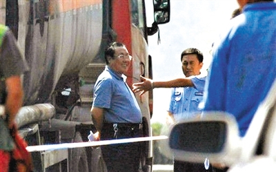 An online photo shows Yang Dacai, an official in charge of workplace safety in Shaanxi Province, was caught smiling during his inspection of a road accident in Yan'an, Shaanxi on August 26, 2012.