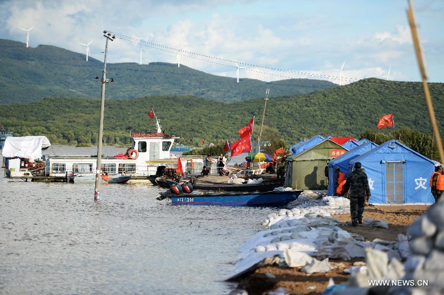 The water level of floods nearly reaches the embankment in Jiejinkou area in Tongjiang City, northeast China's Heilongjiang Province, Aug. 28, 2013. The Songhuajiang River mingles with the Heilongjiang River at Tongjiang. The water level of Tongjiang section of the Songhuajiang River and the Heilongjiang River reached 56.63 meters and 56.05 meters, exceeding the warning level by 1.73 meters and 2.05 meters respectively. [Wang Kai/Xinhua]