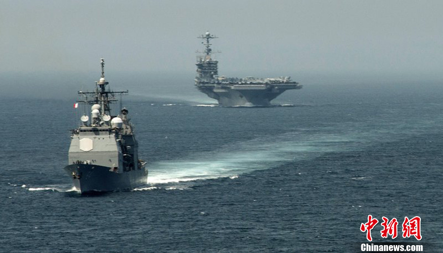 In a BBC interview, U.S. Defence Secretary Chuck Hagel said the U.S. forces stands ready to strike Syria if President Obama gives order. Photo taken on Aug. 15 shows the guided-missile cruiser USS Gettysburg and the aircraft carrier Harry S. Truman. [Chinanews.com]