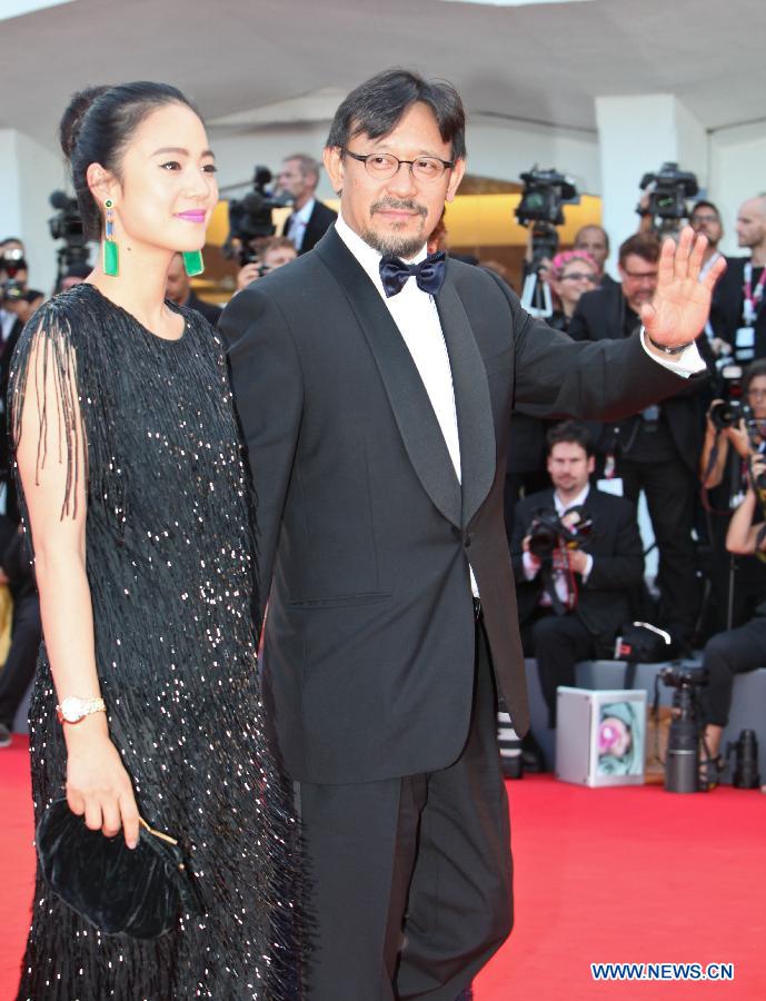 Member of the international Jury of Venezia 70 Jiang Wen (R) walks on the opening ceremony red carpet of the Venice Film Festival with his wife Zhou Yun on the Lido island of Venice , Italy, Aug. 28, 2013. [Yan Ting/Xinhua]