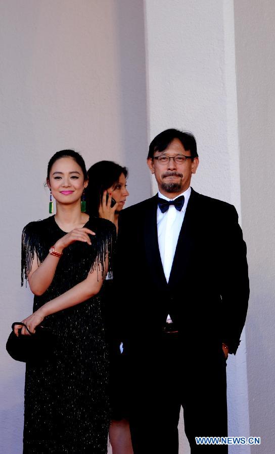 Chinese director Jiang Wen and his wife Zhou Yun show on the red carpet of the opening ceremony of the 70th edition of Venice Film Festival on lido island, Venice, on August 28, 2013.[Xu Nizhi/Xinhua]