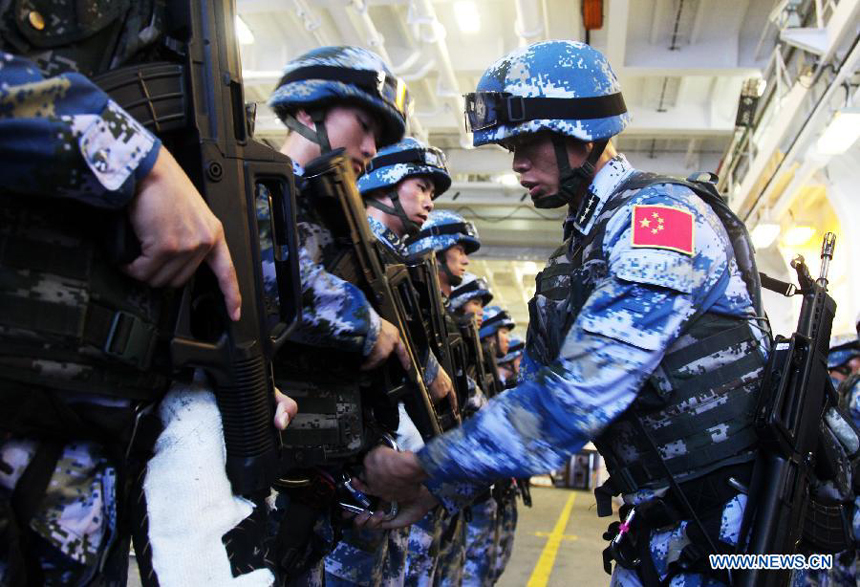 Chinese special troop soliders of the 15th convoy fleet carry out safety checks before participating in a night training on the Jinggangshan vessel in the Gulf of Aden, on Aug. 28, 2013. 