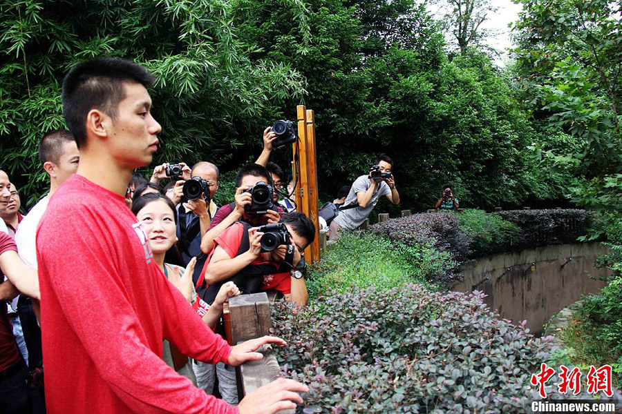 Houston Rockets basketball player Jeremy Lin visits the Chengdu Research Base of Giant Panda Breeding in Sichuan province August 29, 2013. [Photo: Chinanews.com] 