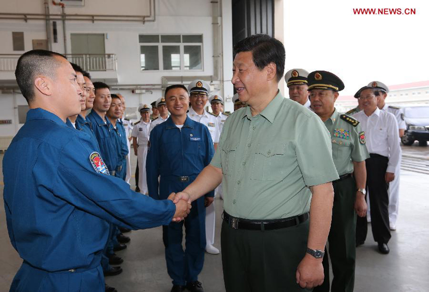 Chinese President Xi Jinping (R, front), who is also the chairman of the Central Military Commission and general secretary of the Communist Party of China Central Committee, shakes hands with a soldier after he watched take-off and landing training of carrier-based aircraft in northeast China&apos;s Liaoning Province, Aug. 28, 2013. Xi visited the Shenyang military theater of operations before attending the Saturday opening ceremony of the 12th National Games in Shenyang. 