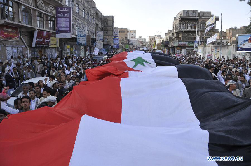 Yemeni protesters hold the Syrian national flag to show support for the Syrian government during a demonstration held in Sanaa, Yemen, on Aug. 30, 2013. Thousands of Yemeni people took to street to announce their refusal of possible U.S.-led military attack on Syria. 