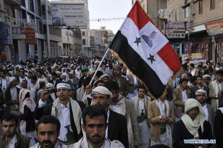 A Yemeni protester holds the Syrian national flag to show support for the Syrian government during a demonstration held in Sanaa, Yemen, on Aug. 30, 2013. Thousands of Yemeni people took to street to announce their refusal of possible U.S.-led military attack on Syria.