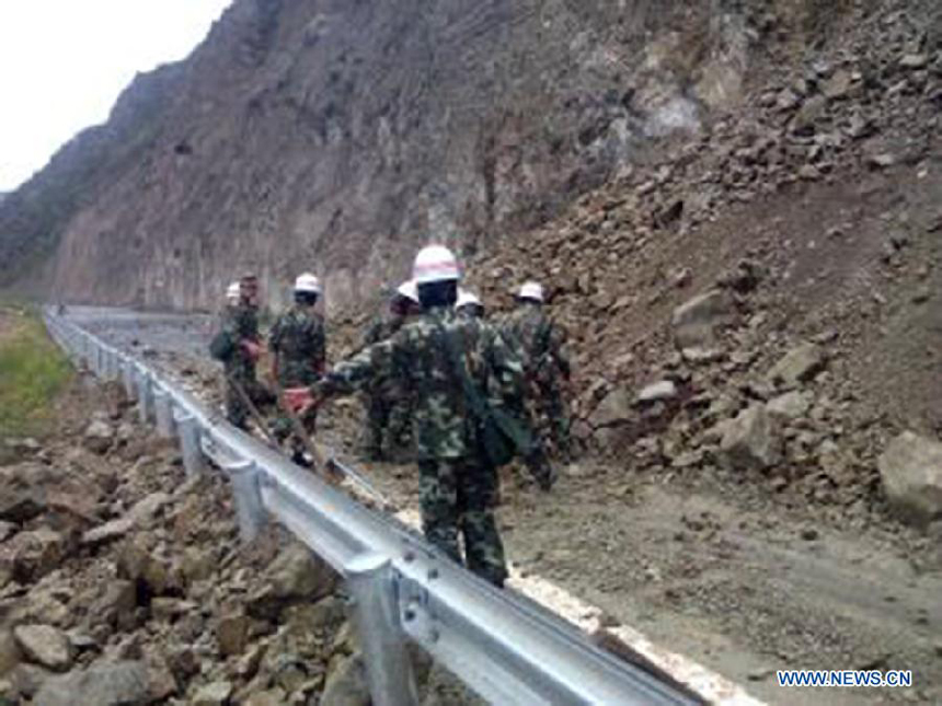 Photo taken on Aug. 31, 2013 by mobile phone shows landslides triggered by the quake on a road in Benzilan Township of Deqen County, southwest China&apos;s Yunnan Province.