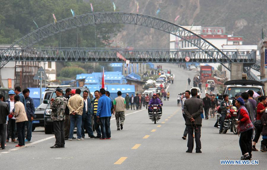 People stand outdoors after an earthquake at Benzilan Township in Deqen County, southwest China&apos;s Yunnan Province, Aug. 31, 2013. 