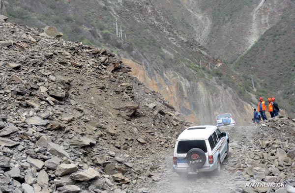 Rescue vehicles pass through the No. 214 national road leading to the quake-hit Benzilan Township of Shangri-La County, southwest China's Yunnan Province, Sept. 1, 2013. A 5.9-magnitude quake jolted southwest China's Yunnan and Sichuan provinces on Saturday morning.