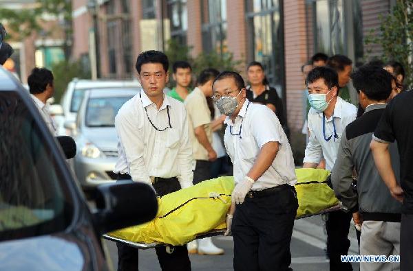 Workers carry the body of a victim of a leak accident in the Baoshan District of Shanghai, east China, Aug. 31, 2013.