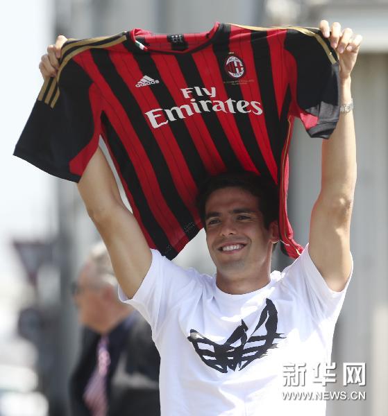 Ricardo Kaka of Brazil holds up the Milan jersey upon his arrival at the Linate airport, in Milan, Italy, Monday, Sept.2, 2013. Kaka agreed to contract terms with AC Milan on deadline day and reportedly accepted cutting his salary by more than half to rejoin his former club.