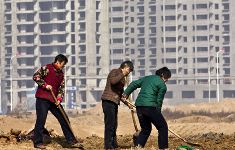 Villagers prepare to plant crops in Huaxian County, Henan Province, in March, in front of apartments into which they are soon to move. [China Daily]
