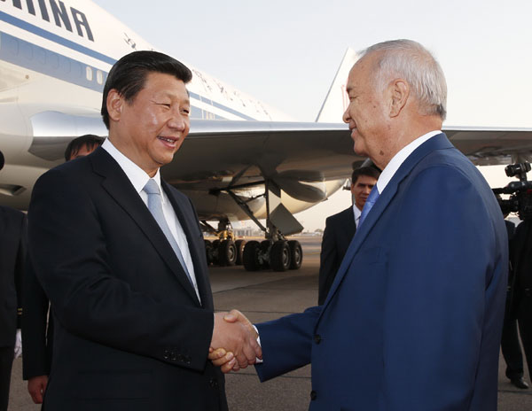 Chinese President Xi Jinping (L) is welcomed by Uzbekistan's President Islam Karimov at the airport in Tashkent, Uzbekistan, Sept 8, 2013. [Xinhua] 