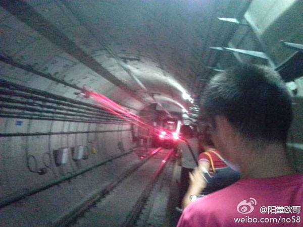 Passengers walk through an emergency passageway as the train was evacuated on Sunday, September 8, 2013. A train running on Hangzhou subway's line one powered down in the tunnel-way that travels under the Qiantangjiang river. [Photo: weibo.com]