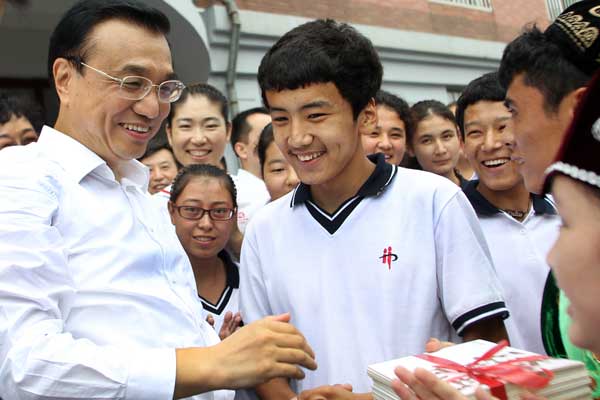 Premier Li Keqiang talks with Xinjiang students at Dalian No 20 Senior High School in Liaoning province on Monday, one day before Teachers' Day. ZOU HONG / CHINA DAILY
