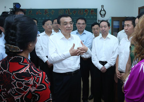 Chinese Premier Li Keqiang talks with students of the ethnic minorities at No. 20 High School of Dalian, northeast China's Liaoning Province, Sept. 9, 2013. Li stressed raising education quality in underdeveloped regions while visiting teachers in Dalian on Monday ahead of Teachers' Day on Sept. 10. [Photo/Xinhua] 