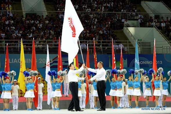  Liu Peng (R), president of Chinese Olympic Committee and head of China's State General Administration of Sports gives the flag of national games of China to Tianjin mayor Huang Xingguo during the closing ceremony of the 12th Chinese National Games in Shenyang, northeast China's Liaoning Province, Sep 12, 2013. Tianjin will host the 13th National Game in 2017. (Xinhua/Li Gang)