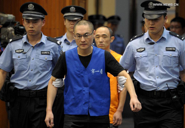 Han Lei (C front), who has been charged with intentional homicide for killing a 34-month-old toddler, and Li Ming, who helped Han flee the scene, are escorted by police to the court of the Beijing No. 1 Intermediate People's Court, Beijing, Sept. 16, 2013.