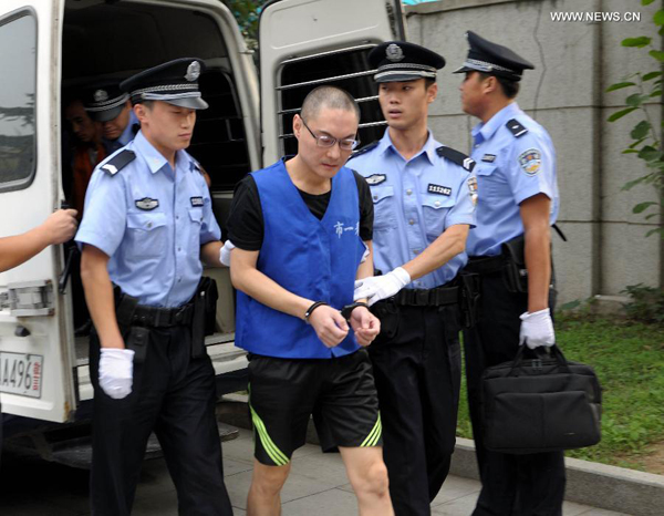 Han Lei, who has been charged with intentional homicide for killing a 34-month-old toddler, is escorted by police to the Beijing No. 1 Intermediate People's Court, Beijing, Sept. 16, 2013.