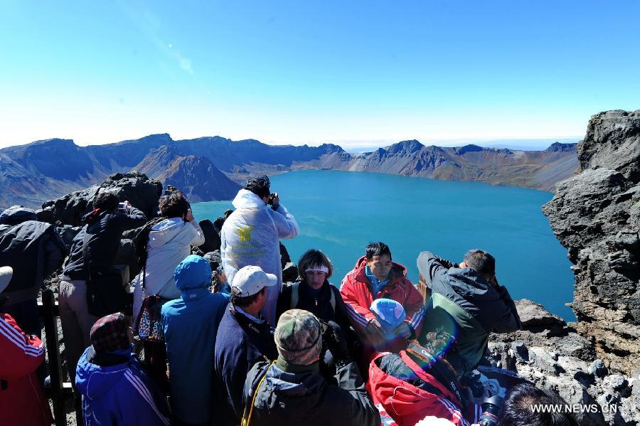 Visitors take photo of Tianchi Lake on the Changbai Mountain, northeast China&apos;s Jilin Province, Sept. 15, 2013. The Changbai Mountain will witness a travel peak as the Mid-Autumn Festival and the National Day holidays are coming.