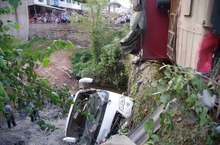 Photo taken on Sept. 15, 2013 shows the site where a road accident occurred in Zhenwu Village, Dazhou City, southwest China&apos;s Sichuan Province. Sixteen people, including 11 students, have been confirmed dead in the road accident, when a passenger bus collided with a truck, and then fell off a bridge. 