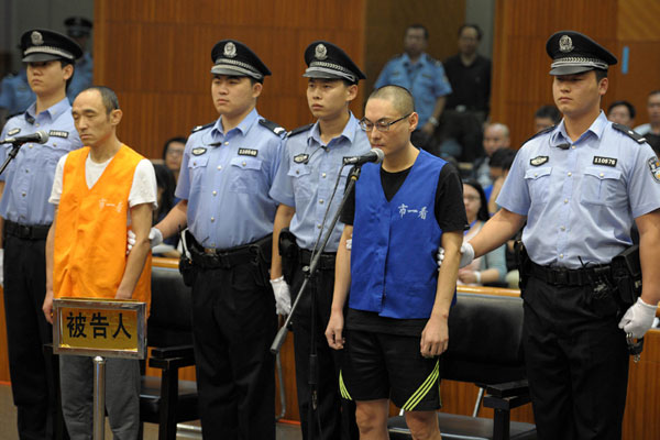 图为被告人李明（左）和韩磊在庭审现场。[新华社]